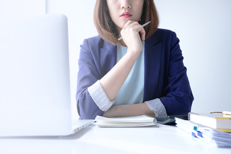 beautiful young business woman working in the office or home with paperwork calculator laptop and computer.の写真素材