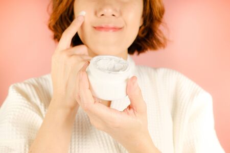 beauty and fashion pink background.woman with cosmetic and skincare product . facial cream serum and moisturizer spa content. asian people with makeup.の写真素材