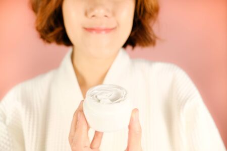 beauty and fashion pink background.woman with cosmetic and skincare product . facial cream serum and moisturizer spa content. asian people with makeup.の写真素材