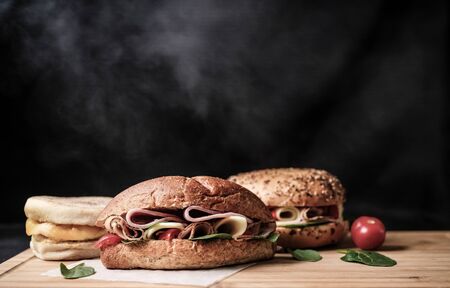 Delicious classic blt sandwiches with ham, cheese, bacon, tomatoes. Breakfast and fast food meal. on isolated black background wooden and text copy space.の写真素材