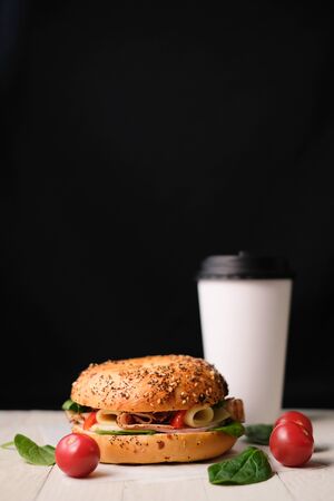 Delicious classic blt sandwiches with ham, cheese, bacon, tomatoes. Breakfast and fast food meal box set with drink on isolated black background wooden and text copy space.の写真素材