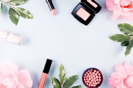 Beauty background makeup cosmetic product,with green leaf and pink rose blossom on purple spring background. woman mother day concept. flatlay topviewの写真素材