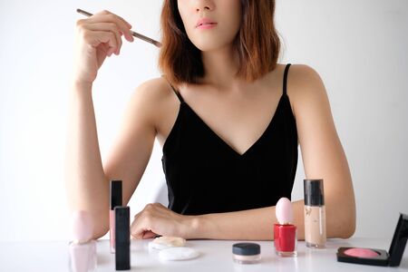 Young beautiful woman applying make up.の写真素材