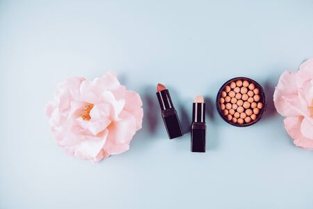 Beauty background makeup cosmetic product,with green leaf and pink rose blossom on purple spring background. woman mother day concept. flatlay topviewの写真素材