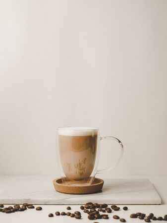 Ice coffee in the glass topped whipping cream with coffee beans. Cold summer drink on wooden background and copy space. Advertising for caramel mocha and chocolate beverage for the cafe.の写真素材