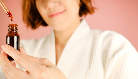 beauty and fashion pink background.woman with cosmetic and skincare product . facial cream serum and moisturizer spa content. asian people with makeup.の写真素材