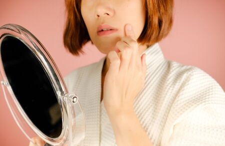 beauty and fashion pink background.woman with cosmetic and skincare product . facial cream serum and moisturizer spa content. asian people with makeup.の写真素材