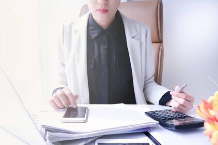young asian entrepreneur working in the office or home with paperwork calculator laptop and computer. financial accounting concept.の写真素材