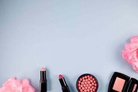 Beauty background makeup cosmetic product,with green leaf and pink rose blossom on purple spring background. woman mother day concept. flatlay topviewの写真素材