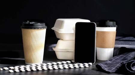 biodegradable cardboard paper coffee cup and food package . eco friendly drink packaging with mobile phone application.の写真素材