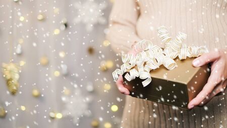 Hand hold gift for Christmas and new year background banner with the beautiful decor for holiday in winter. On bright blue, golden and silver color theme with snow flake. top view with copy space.の写真素材