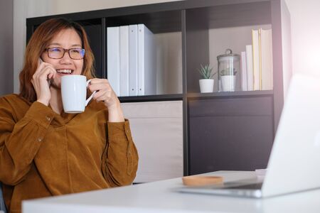 asian adult entrepreneur work on laptop and mobile phone with paperwork in the smart officeの写真素材