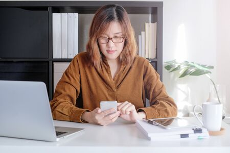 asian adult entrepreneur work on laptop and mobile phone with paperwork in the smart officeの写真素材