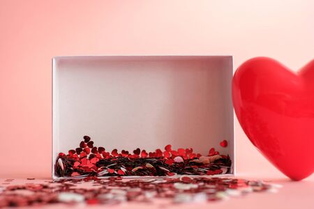 Valentine's Day background . red gloss heart with confetti on pink pastel background with copy space. wedding wallpaper.の写真素材