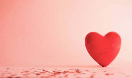 Valentine's Day background . red gloss heart with confetti on pink pastel background with copy space. wedding wallpaper.の写真素材