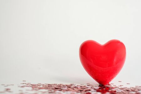 Valentine's Day background . red gloss heart with confetti on pink pastel background with copy space. wedding wallpaper.の写真素材