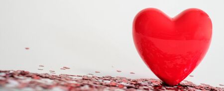 Valentine's Day background . red gloss heart with confetti on pink pastel background with copy space. wedding wallpaper.の写真素材