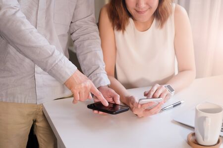 asian adult entrepreneur work on laptop and mobile phone with paperwork in the smart officeの写真素材