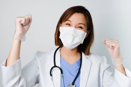 happy asian doctor wear the medical mask to protect and fight infection from germ, bacteria, covid19, corona , sars , influenza virus on white background with the happy face.の写真素材