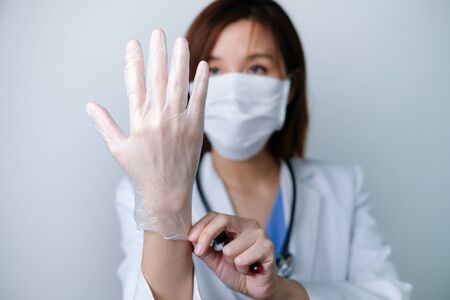 Doctor wearing the glove to prevent disease and fight , infection, covid19, corona virus.の写真素材