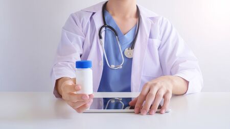 doctor hold the medicine and use the digital tablet . health care and medical concept.の写真素材