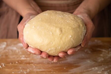 chef preparing bread dough on wooden table in a bakery.の写真素材