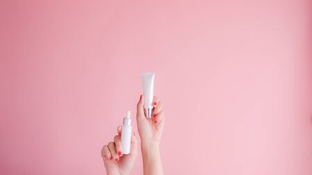 hand hold cosmetic skincare on pink background.beauty banner.の写真素材