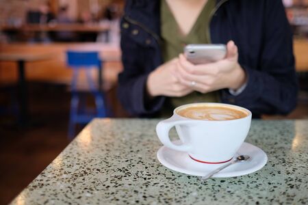 woman used the mobile phone at he coffee cafe.の写真素材