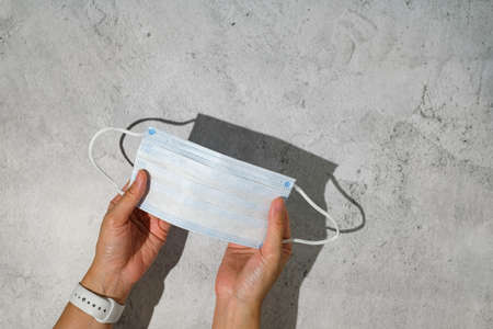 hand holding surgical face mask for new normal life.の写真素材