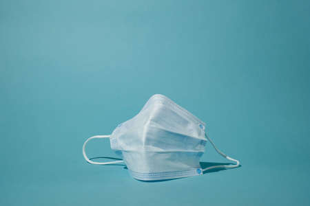 surgical face mask on blue background for new normal life.