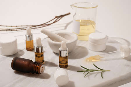 cosmetic and skin care for beauty routine on white background with shadow. modern and minimal product design with essential oil, pestle and mortar.の写真素材