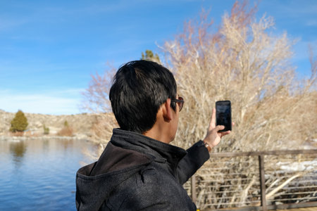 travel man use smart phone o taking photo of the beautiful mountain landscape.のeditorial素材