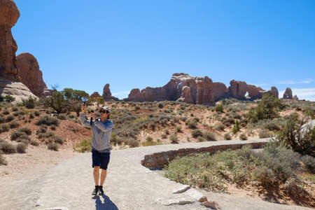 man is hiking and doing photography at arches nation park .travel and explore Utah USA concept.の写真素材