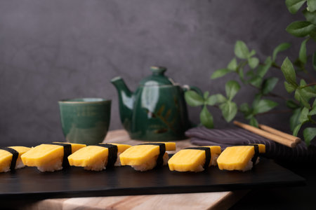 Japanese sweet egg sushi with hot tea. traditional food and meal.の写真素材