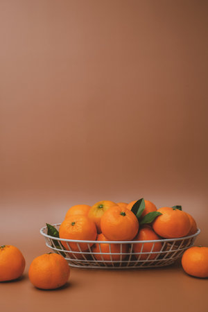 orange, mandarin, or tangerine in the wire basket on brown background. Nutrition and benefit of fruit concept.の写真素材