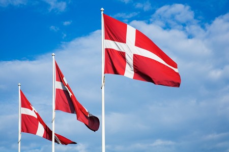 Danish Flags against a blue sky with cloudsの写真素材