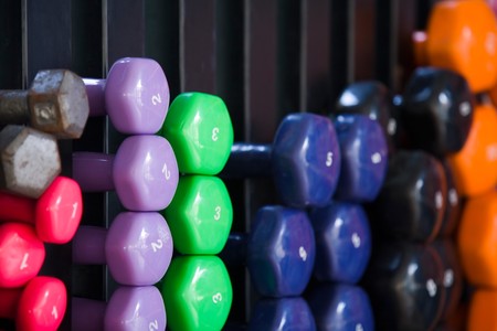 Closeup of multicolored dumbbells on a rack in a fitness studioの写真素材