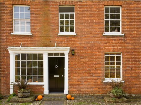 Front of a traditional house with halloween pumpkins on the doorstepの写真素材