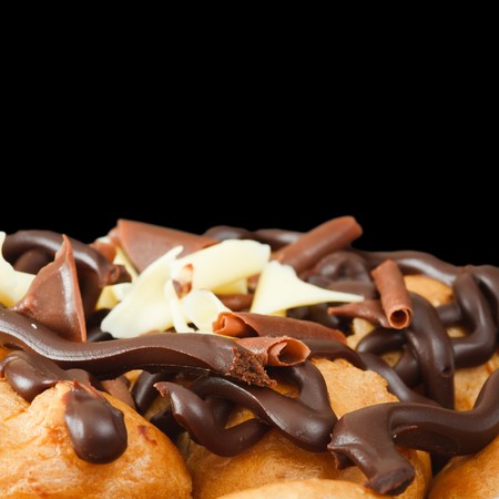 Profiteroles with chocolate isolated against a black background with copy spaceの写真素材