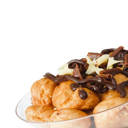 Bowl of profiteroles smothered in chocolate, isolated against a white background with copy space