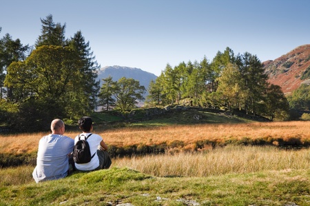 A mixed race couple enjoy a scenic view in Borrowdale, Lake District, Cumbria, UK. Caucasian man, Indian Asian woman.の写真素材