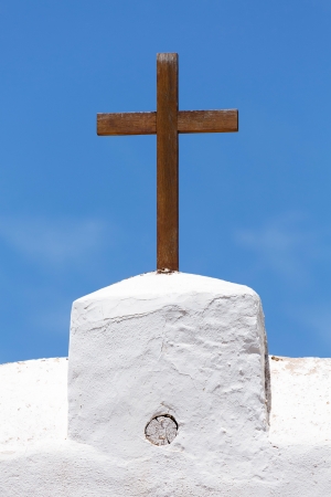Christian cross of wood on a white church against a blue skyの写真素材