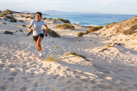 Young Indian female jogging outdoors by the seaの写真素材
