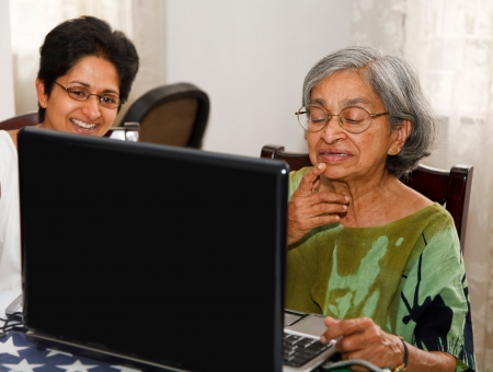 Indian mother and daughter surfing the internet on a laptopの写真素材