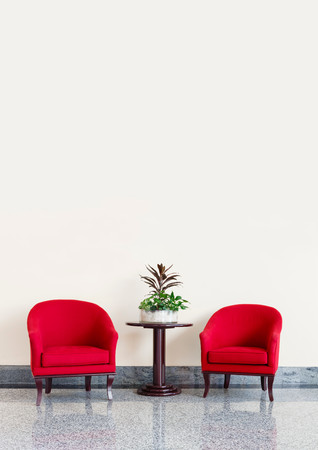 Red armchairs against a neutral wall background with copyspaceの写真素材
