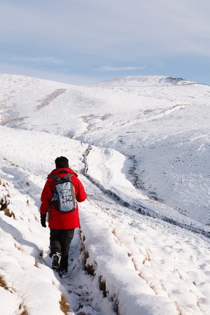 Indian woman hiking in winter snow, Peak District, UKの写真素材