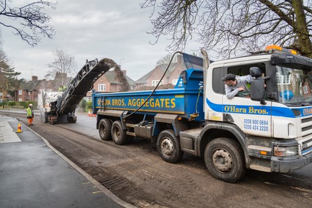 LONDON, UK - CIRCA 2013: Highway contractors resurface the tarmac of a suburban road in London, UKのeditorial素材