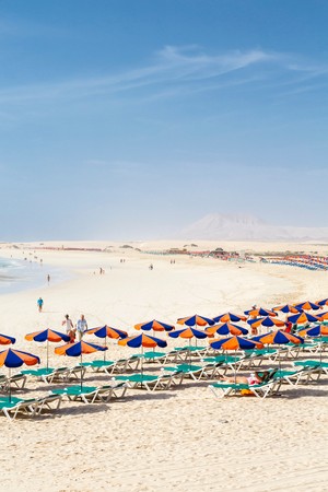 FUERTEVENTURA, SPAIN - CIRCA 2013: Row of sunbeds and parasols on sandy beach Bajo Negro, Fuerteventura, Canary Islandsのeditorial素材