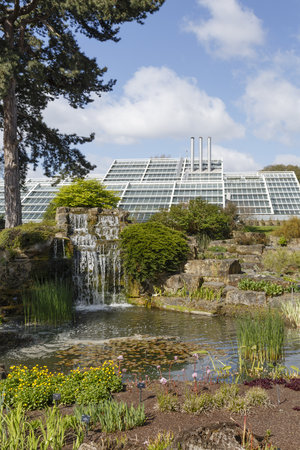 London, UK - April 18, 2014. Rock garden and Princess of Wales Conservatory in Kew Botanic Gardens. The gardens were founded in 1840 and are of international significance for botanical research and education.のeditorial素材