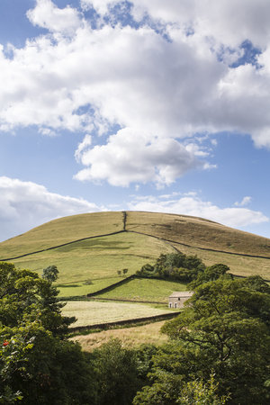English rural scene of fields separated by dry stone walls on a hill in Edale Valley, Derbyshire, UKの写真素材